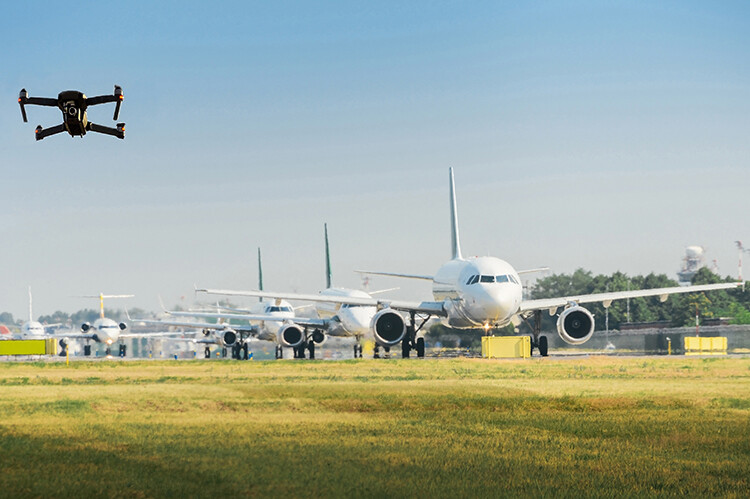 Unmanned drone flying near airplanes at airport